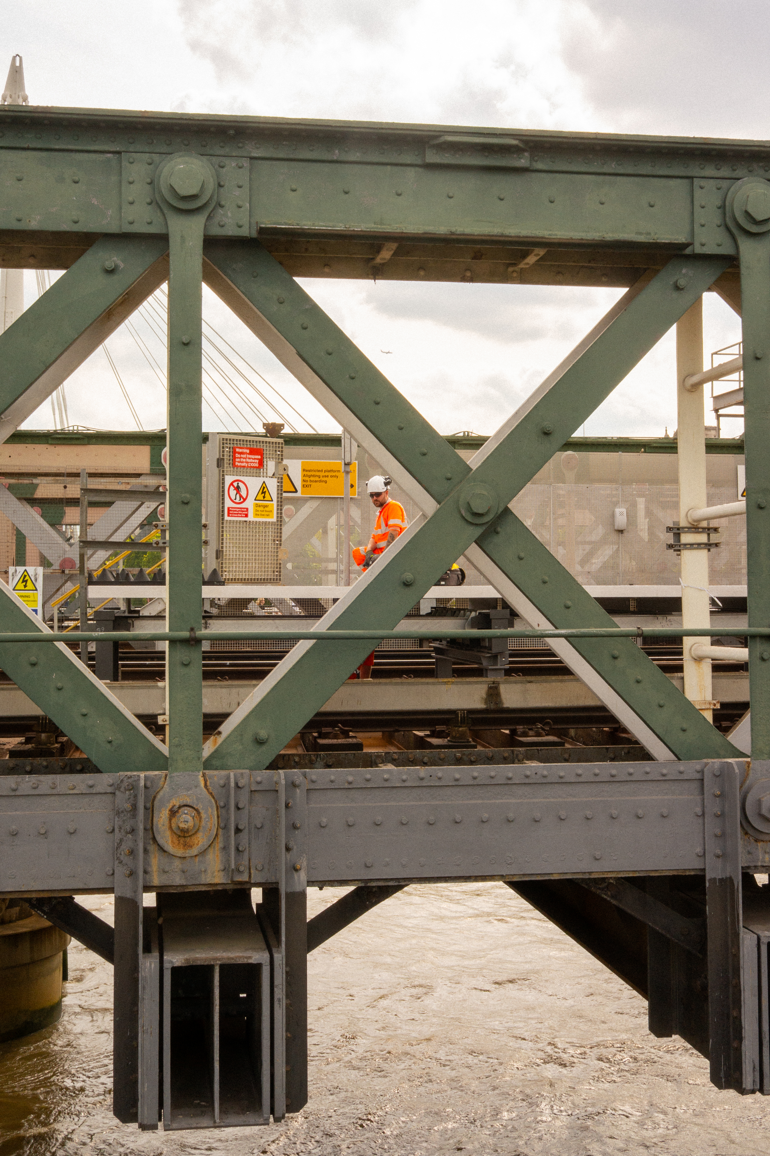 A man in a hi-vis suit on some tracks looking towards the camera